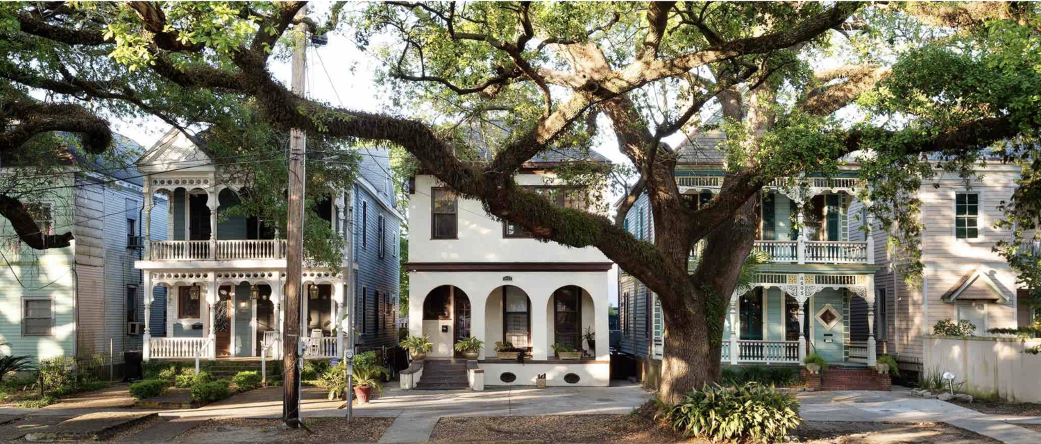 boutique hotel exterior home with trees on a street
