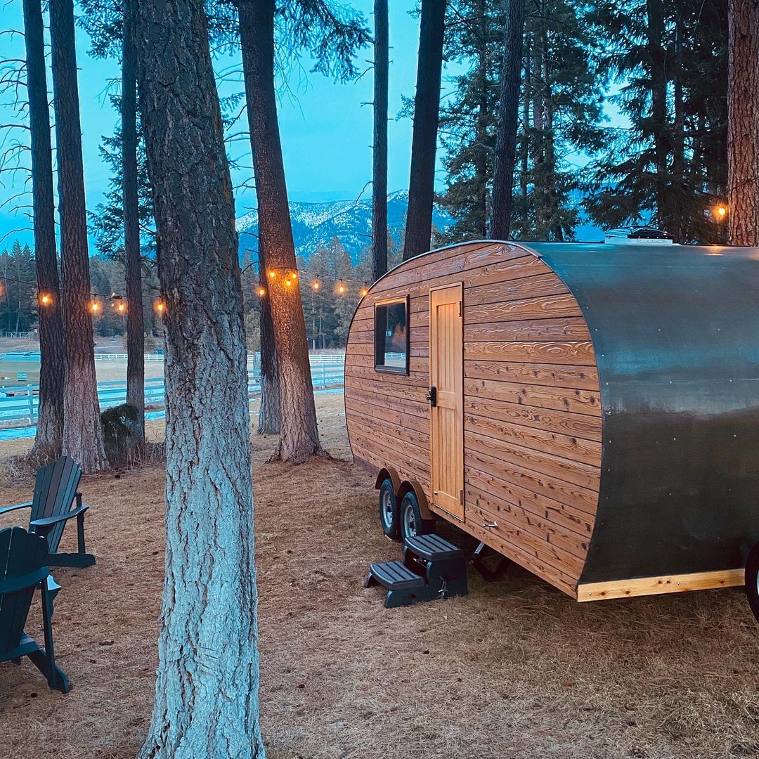 string lights on trees with luxury glamping trailer