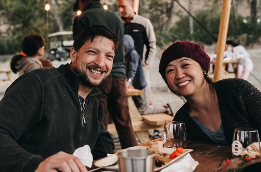 people smiling while eating at campsite